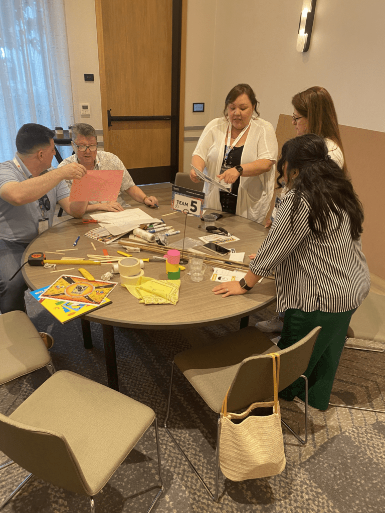 Team members work together on planning their bridge design during the Bridging the Divide team building activity.