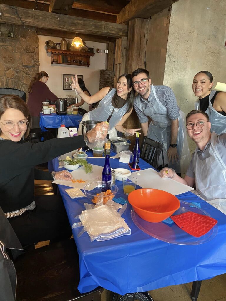 Participants happily preparing ingredients during a Wicked Good Chowda Cook-Off team building event.