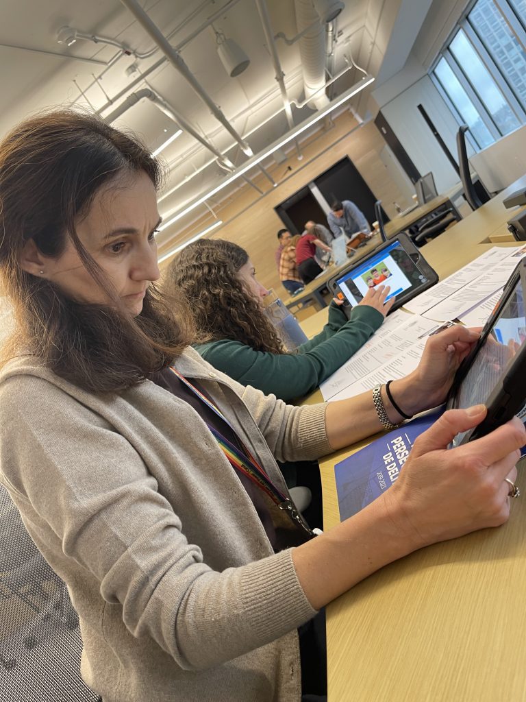 Participant focuses on analyzing clues on a tablet during the Corporate CSI team building activity.