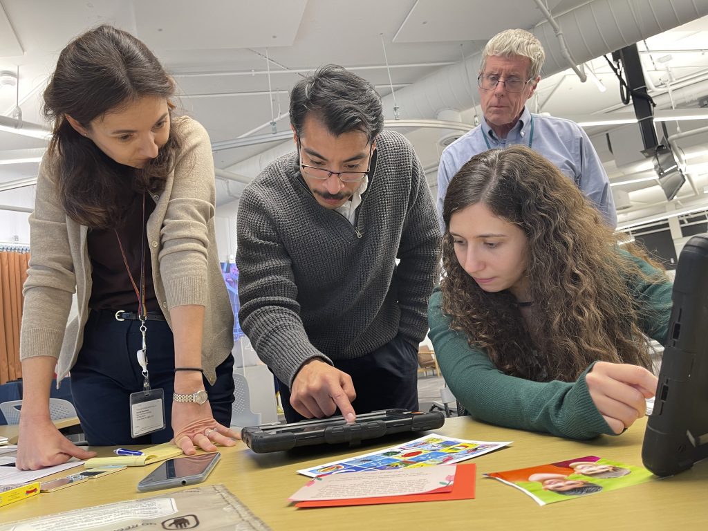 Participants collaborate while analyzing evidence on a tablet during the Corporate CSI team building event.