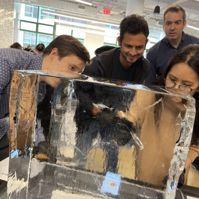 Participants focused on sculpting a block of ice during a Team building Ice Sculpting event, collaborating to create impressive works of art.