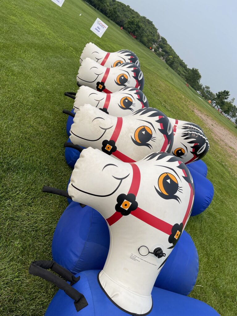 Inflatable horse props lined up and ready for a fun relay race during an Outrageous Games team building event.