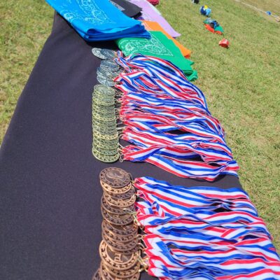 Medals and team flags displayed at an Outrageous Games team building event, ready for the award ceremony after a day of fun challenges.