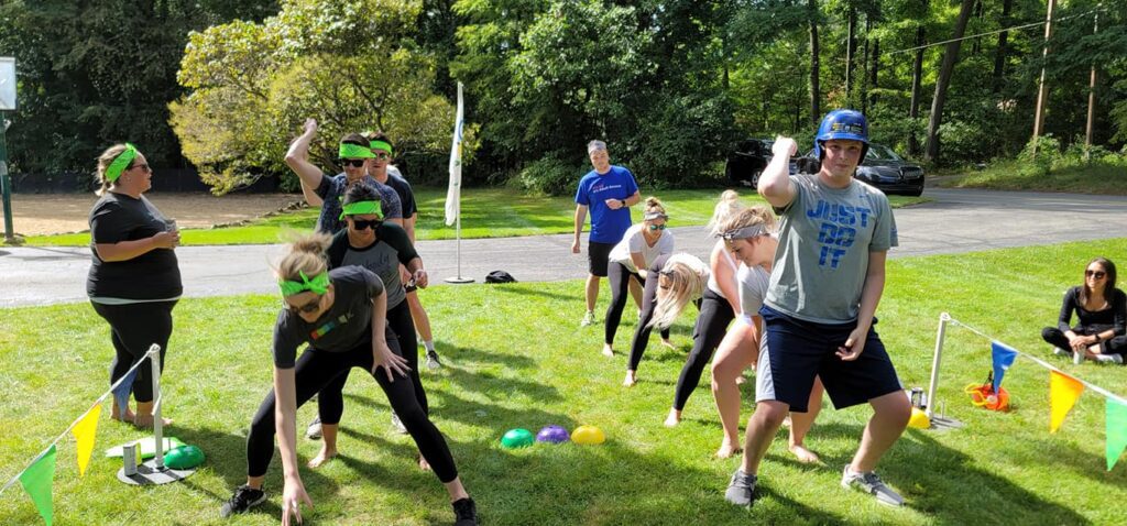 Teams competing in a relay race during the Outrageous Games team building event, fostering collaboration and fun.