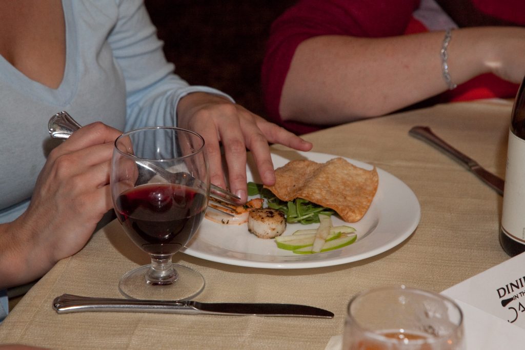 A participant enjoys a meal during a Dining in the Dark team building event, using sensory experiences to enhance connection and teamwork.