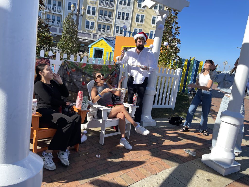 Participants engage in a scavenger hunt challenge during a Custom Team Building event. They are seated outdoors, fulfilling a task as part of the creative and interactive scavenger hunt activity.