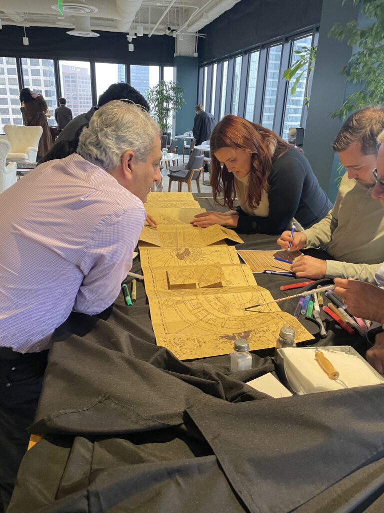 Participants work together on a detailed project involving intricate Harry Potter themed map during a Custom Team Building event.