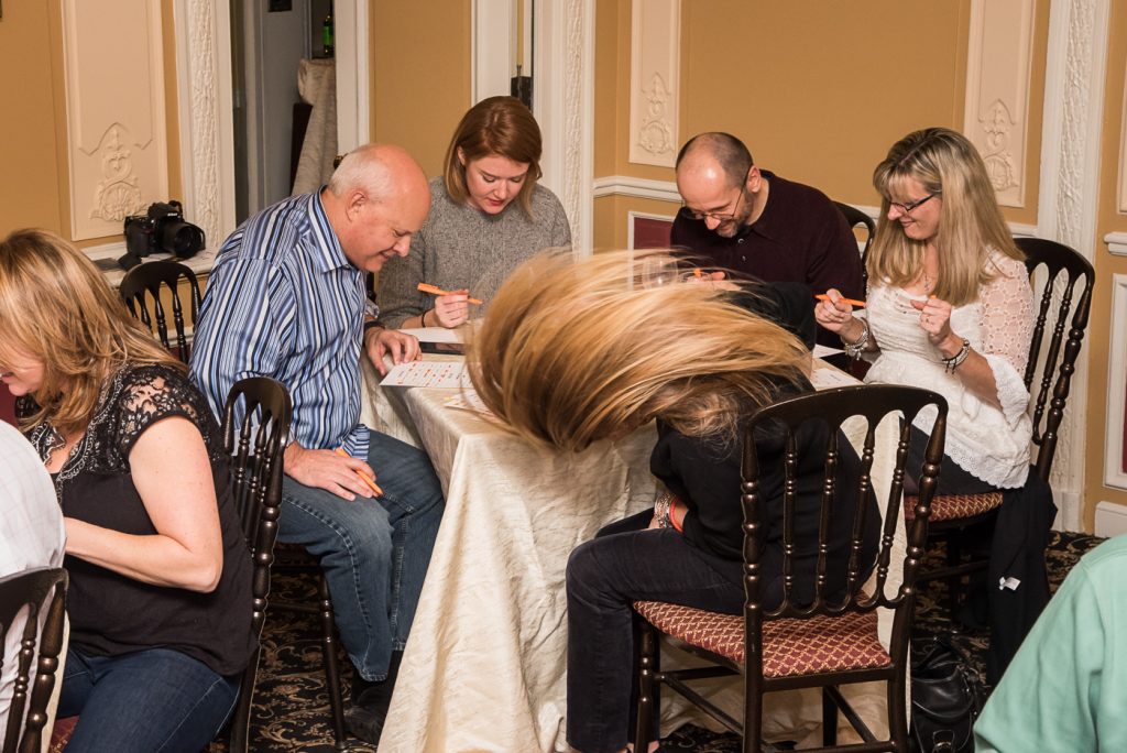 Engaged participants marking their bingo cards during the Wild Card Team Building Bingo event.