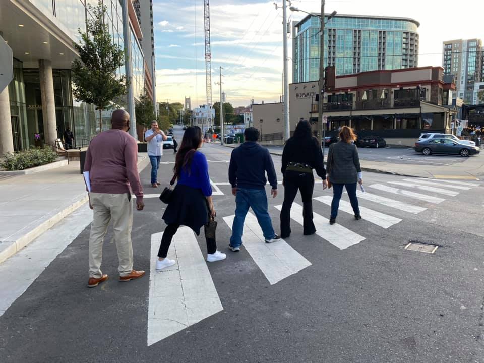 A team of colleagues crossing the street during their Pub Crawl Scavenger Hunt, exploring the city and taking part in fun challenges that encourage collaboration and friendly competition.