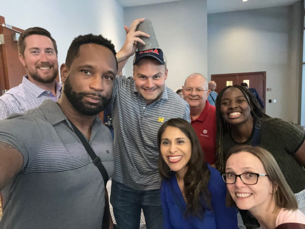 A group of participants posing for a fun selfie during a Team-opoly scavenger hunt team building event.