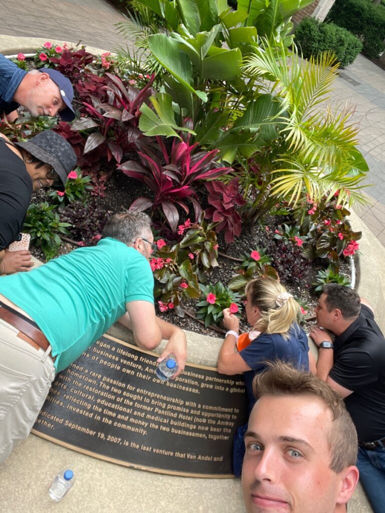 Team searching through plants as part of a scavenger hunt challenge during a team building event.