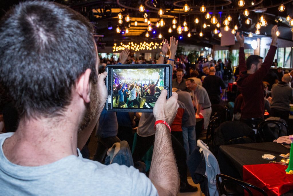 A participant is capturing the high-energy atmosphere of the team as they engage in challenges, showcasing both excitement and collaboration during this fast-paced team building experience.