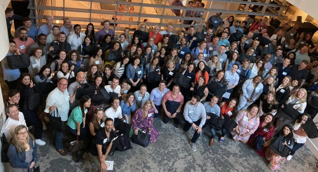 Large group photo from a successful Hopefull Handbags Global team building event, where participants gathered to prepare donations for survivors of domestic abuse.