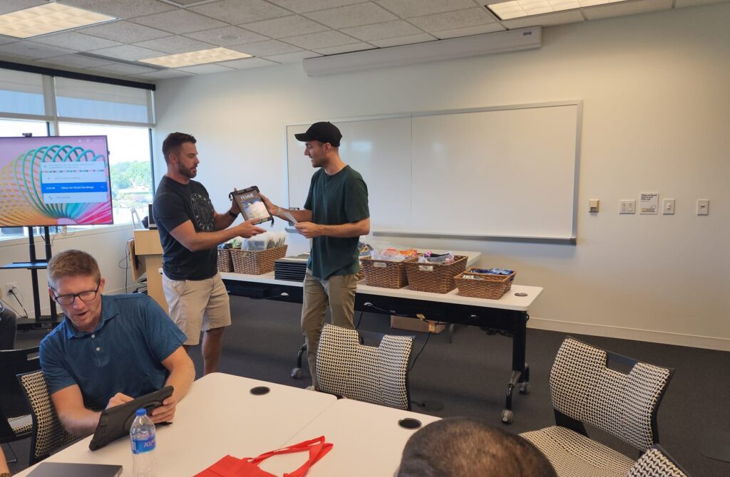 Team members collaborate and exchange items during the Hopefull Handbags Global team building event, packing essential items into handbags for survivors of domestic abuse.