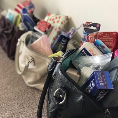 Handbags filled with essential items, ready to be donated to women in need during the Hopefull Handbags Global team building event.