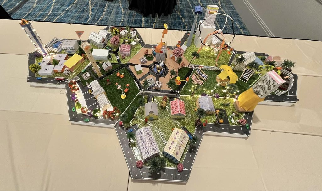 Overhead view of a completed City Build project featuring a connected miniature city with buildings, roads, and parks, created during a collaborative team building activity.