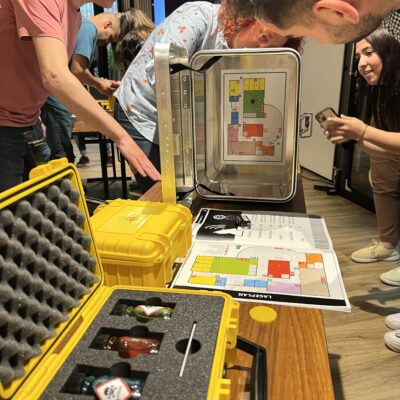 Participants working together to solve puzzles during the 'Atmosphere' team building event, unlocking boxes to find the missing elements for creating a livable atmosphere on Mars.