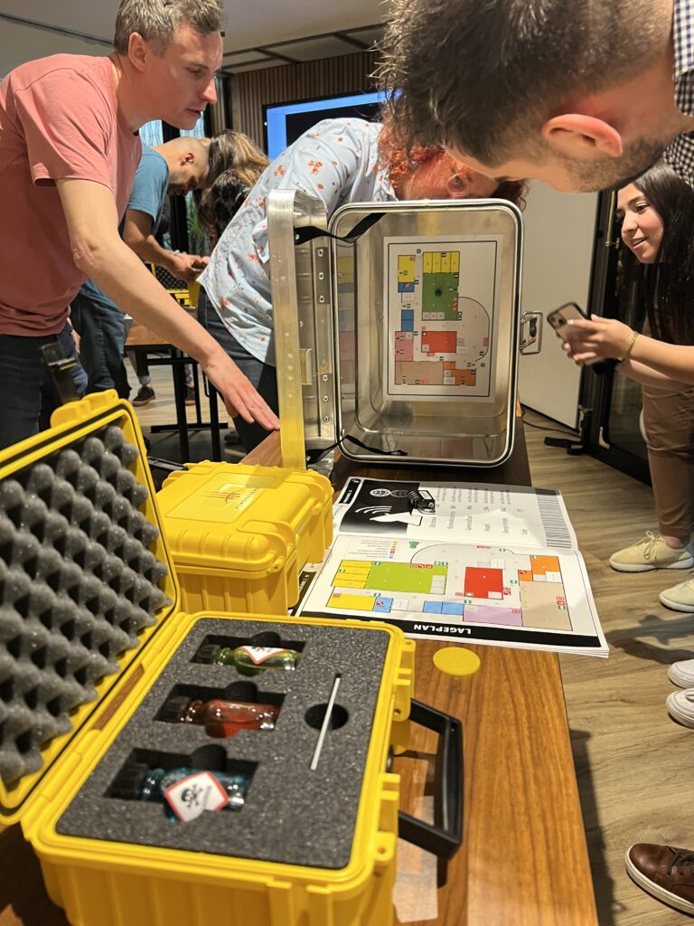 Participants working together to solve puzzles during the 'Atmosphere' team building event, unlocking boxes to find the missing elements for creating a livable atmosphere on Mars.