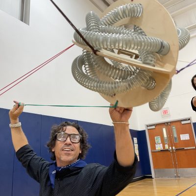 A participant holding a complex structure as part of the Integrity team building event, demonstrating teamwork and balance in a physical challenge.