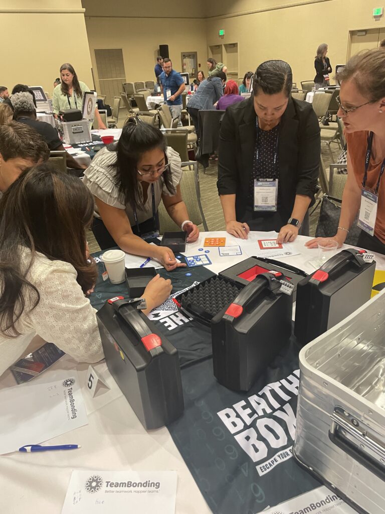 Team intensely solving escape room-style puzzles during the Beat the Box team building event, fostering collaboration and critical thinking.