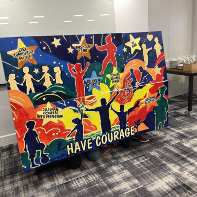 A vibrant mural created during The Big Picture team building event, featuring inspiring messages such as 