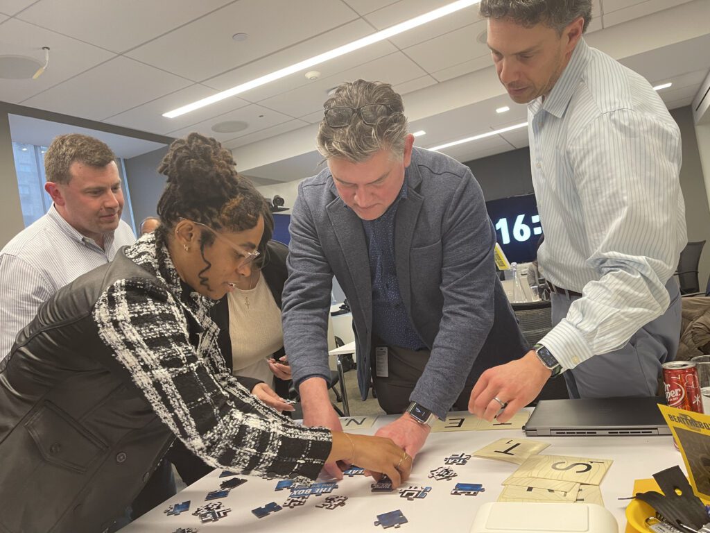 Focused participants work together on a challenging puzzle during a Beat The Box team building event, racing against the clock to achieve success.