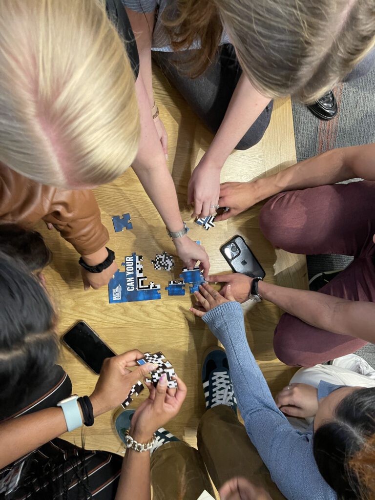 Team members piece together a puzzle as part of the Beat the Box team building activity, fostering collaboration and problem-solving skills to complete the challenge.