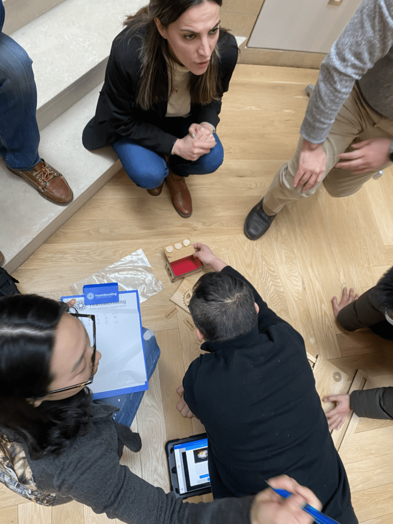 Team members collaborate on a puzzle during the 'Escape The Maze' team building event, using a mix of tools and technology to solve challenges together.