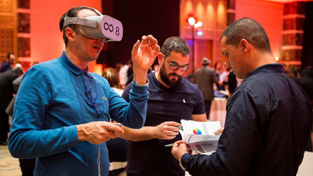 Participant wearing a VR headset during The Infinite Loop team building event, collaborating with teammates to solve virtual challenges. The event emphasizes teamwork, communication, and problem-solving in a virtual reality setting.