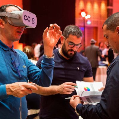 Participant wearing a VR headset during The Infinite Loop team building event, collaborating with teammates to solve virtual challenges. The event emphasizes teamwork, communication, and problem-solving in a virtual reality setting.