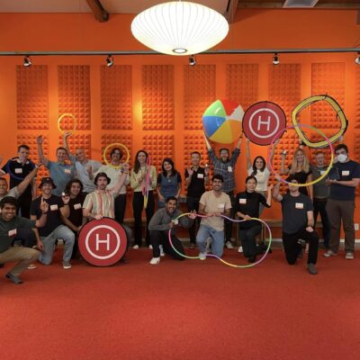 A group celebrates their success in the Game of Drones team building event, posing with drone-themed props and showcasing the power of teamwork and fun competition.