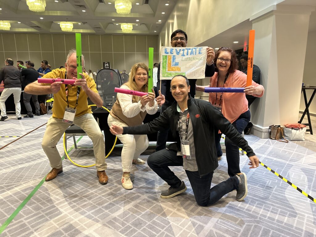 Team enthusiastically posing with colorful drone controllers during a high-energy Game of Drones team building event.