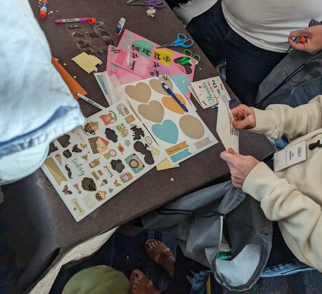 Participants creating appreciation cards with colorful stickers and materials during the Healthcare Heroes scavenger hunt team building program.