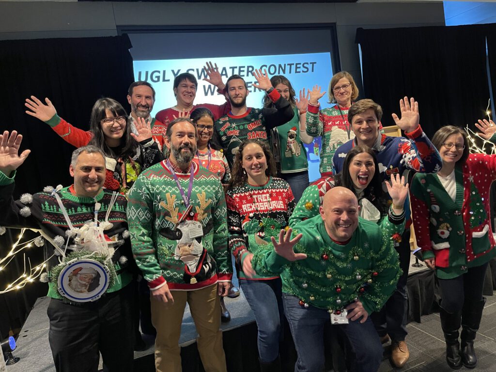 Team members showcase their holiday spirit in festive sweaters during a fun-filled team building holiday party.