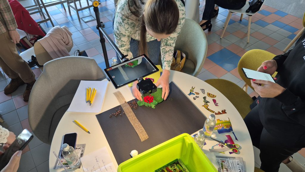 Stop motion animation team building activity. Participants carefully position props and capture frames, collaborating to create a seamless short film while enhancing creativity and communication skills.