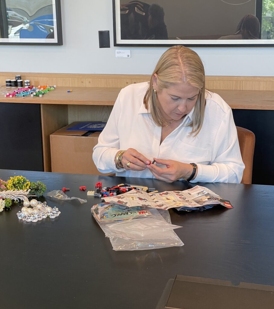 Participant assembling small pieces for a creative stop motion animation project during a team building activity.