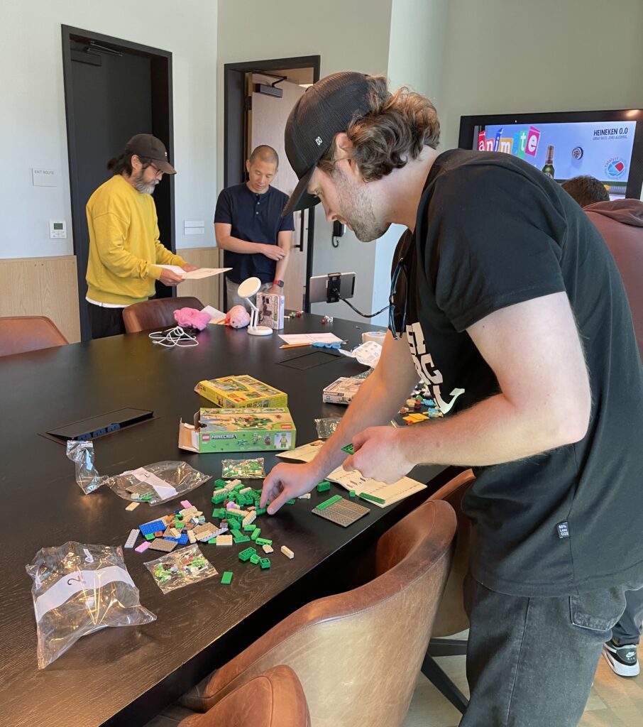 Team member assembling small brick pieces for a stop motion animation project during a hands-on team building event.