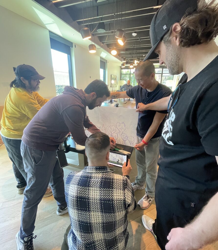 Participants collaborating on a creative stop motion animation project during a team building event, using drawings and props to craft a seamless story.