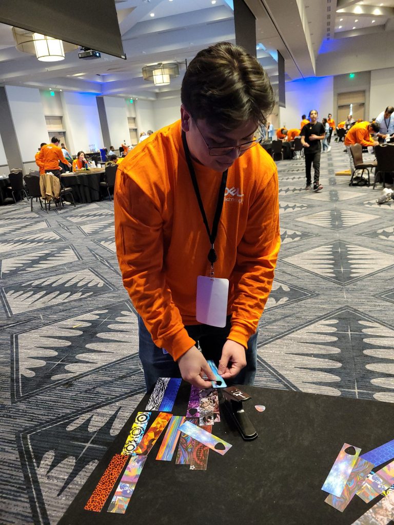 A participant adds creative decorations, such as picks, to go with the guitar donations during the Guitar Build CSR team building program.