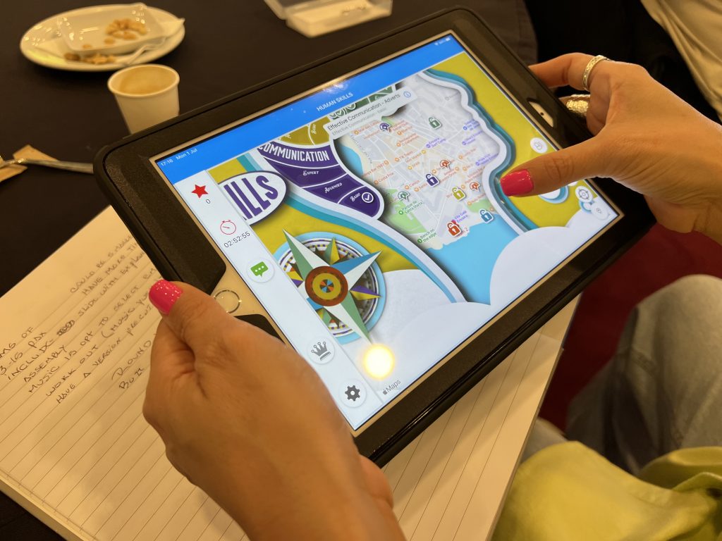 Close-up of a participant using a GPS-enabled tablet during a human skills team building activity. The interactive challenge encourages teamwork, strategic thinking, and problem-solving.