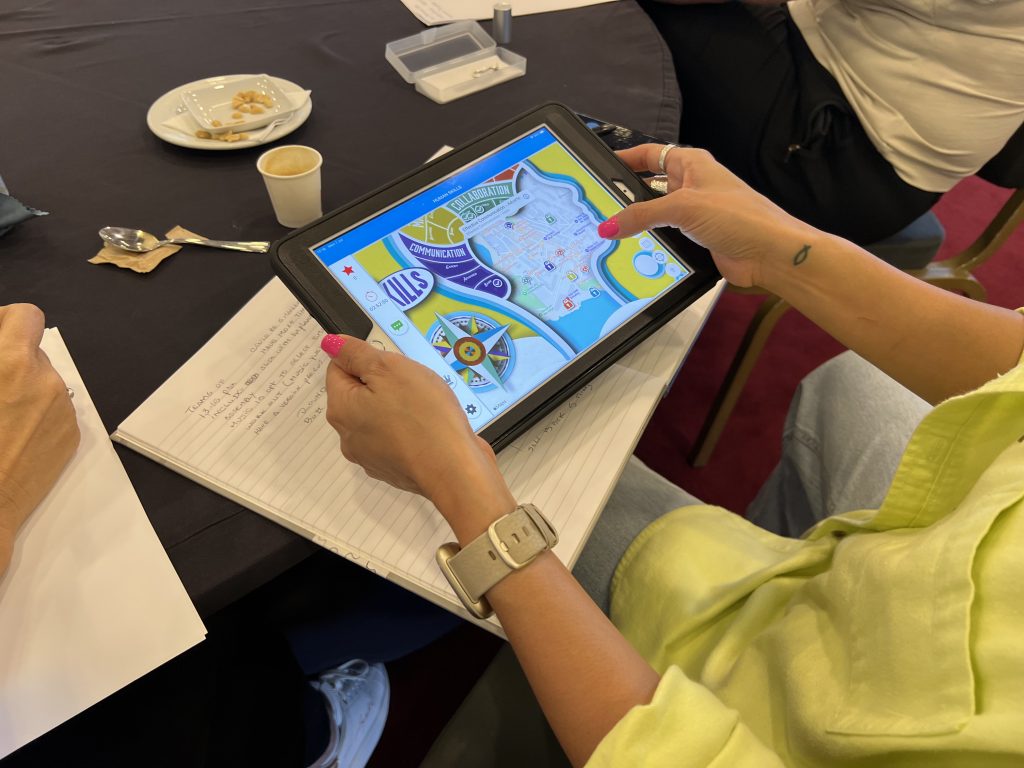 Team building activity using a GPS-enabled iPad for human skills training. A participant navigates challenges and checkpoints, enhancing teamwork, decision-making, and strategic thinking in a dynamic learning experience.