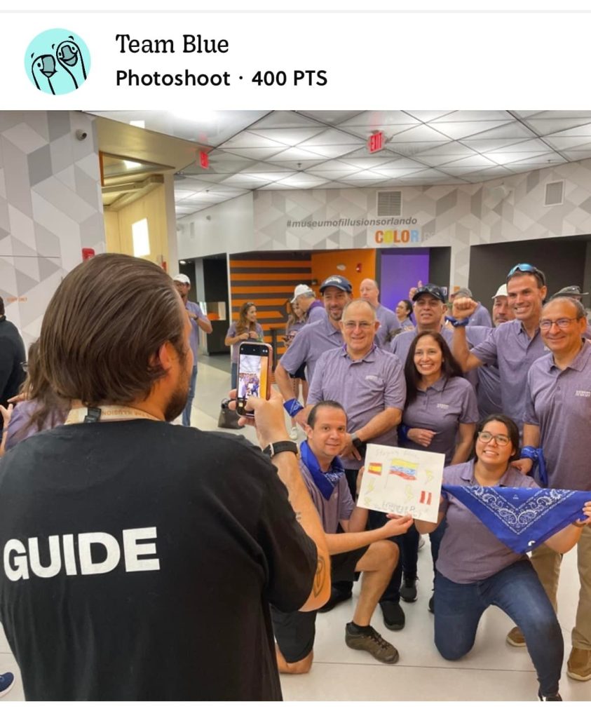 Team Blue celebrating their success during a museum scavenger hunt. A guide captures their victory photo as they proudly display their challenge completion, highlighting teamwork, problem-solving, and fun competition.