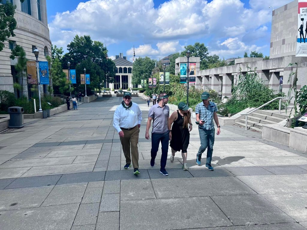 Team exploring an outdoor museum during a scavenger hunt. Participants collaborate to solve challenges, navigate clues, and engage in a fun team building experience that promotes problem-solving and teamwork.