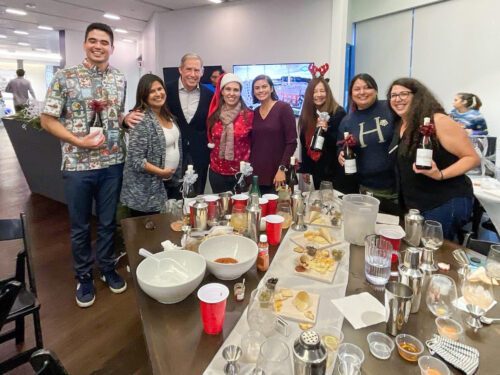 Team celebrating after a successful mixology session, holding their cocktail creations. The event fosters teamwork, creativity, and fun as participants bond over crafting drinks in a lively atmosphere.