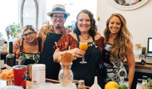 Team members proudly posing with their cocktail creations during a mixology class. The fun, interactive event encourages creativity and teamwork while learning the art of cocktail crafting.